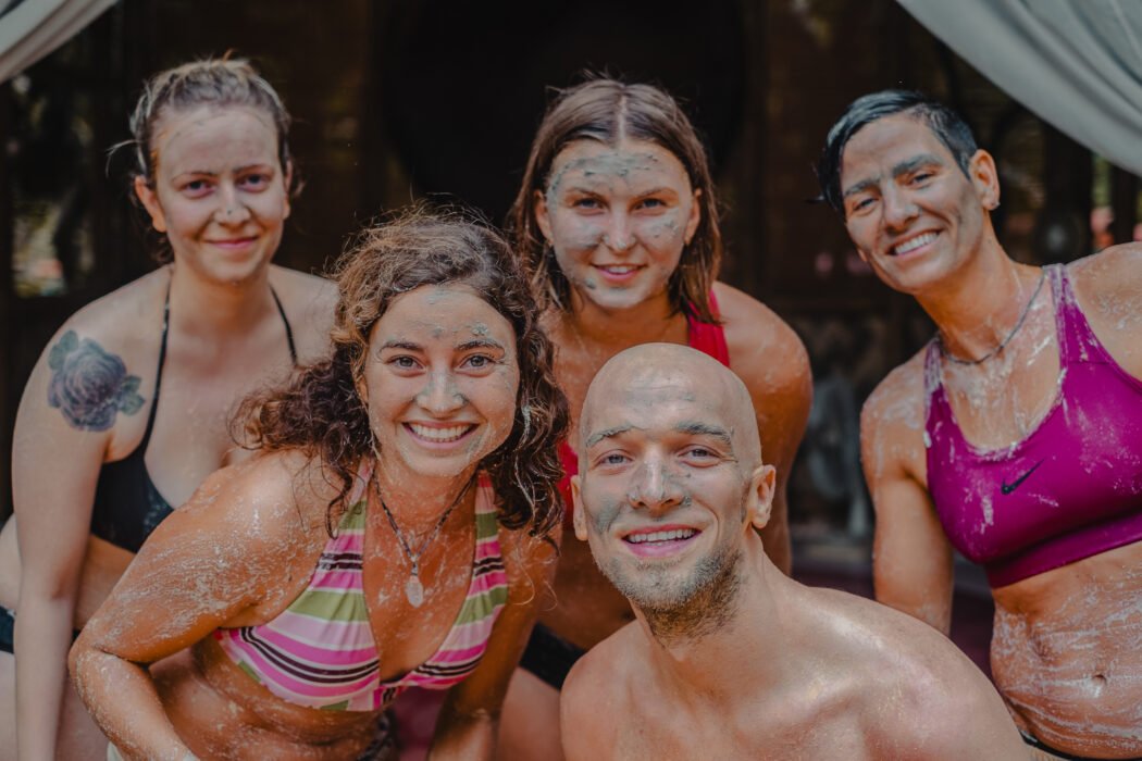Smiling guests covered in mud during a clay body treatment at Bahay Kalipay